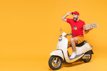 Delivery man in red cap t-shirt uniform driving moped motorbike scooter hold pizza in cardboard flatbox isolated on yellow background studio Fun guy employee working courier Service quarantine concept © ViDi Studio
