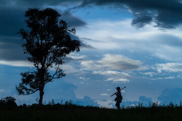 silhouette of a man walking on a hill