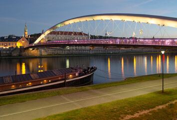 Father Bernatek Footbridge lit up at sunset in Krakow, Poland