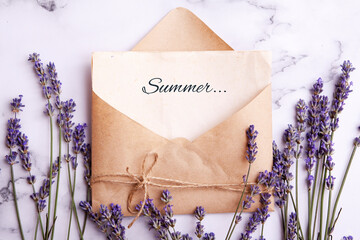 A sheet in an envelope with the inscription Summer on a table with lavender. The concept of summer in the village, Provence