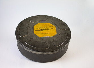 An original old film can with an orange label. For 16 mm film rolls.