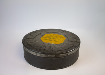 An original old film can with an orange label. For 16 mm film rolls.