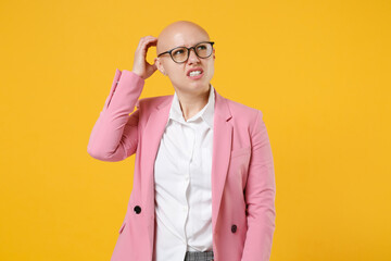 Preoccupied young bald business woman in white shirt pink jacket glasses isolated on yellow background. Achievement career wealth business concept. Mock up copy space. Put hand on head, looking aside.