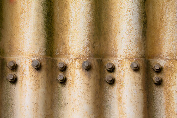 Texture of old weathered corrugated iron. With screws and nuts. You can see the age on the surface.
