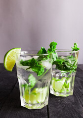 Mojito cocktail or soda drink with lime and mint isolated on wood background