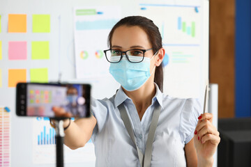 Masked blogger is recording a broadcast on smartphone. Quarantine 2020 online profession coronovirus concept