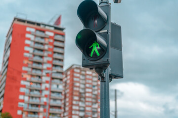 A traffic light with a green little man, safety on the roads
