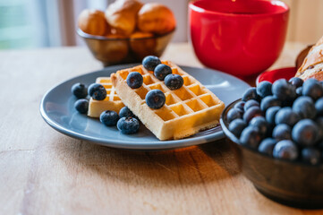 Healthy breakfast of waffles with blackberries, coffee and croissant