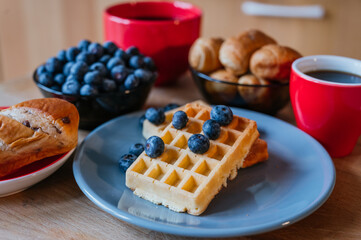 Healthy breakfast of waffles with blackberries, coffee and croissant