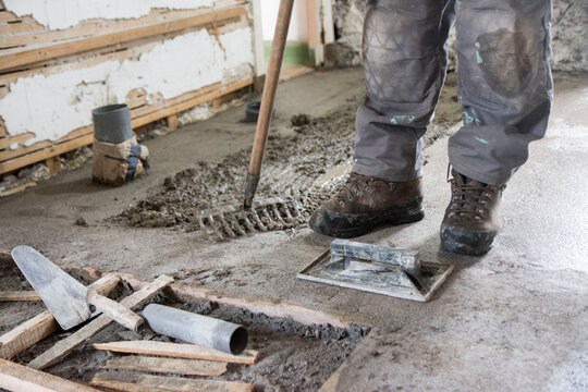 dirty work, production of concrete floor, view of tools and legs of a worker