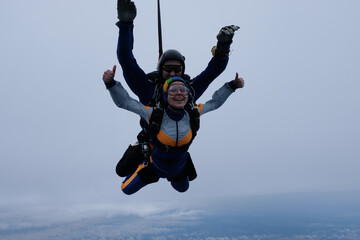 Skydiving. Tandem jump in the cloudy sky.