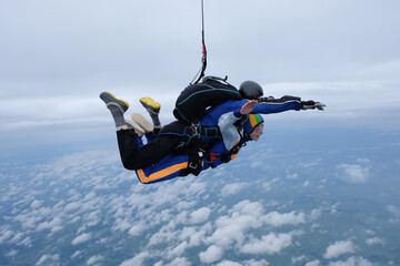 Skydiving. Tandem jump in the cloudy sky.