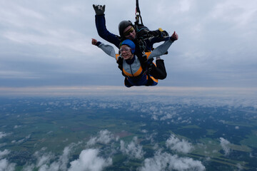 Skydiving. Tandem jump in the cloudy sky.