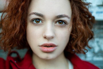 Fashion Portrait. Beautiful Woman in red coat. Curly Hair. soft focus