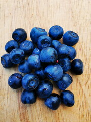 Blueberry (Vaccinium myrtillus). Blueberry fruit on a wooden board, forest fruit.