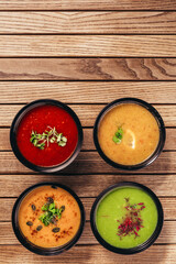 flat lay of cream vegetable soups on wooden table