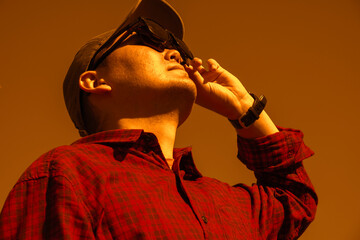 Man is looking on solar eclipse through three sunglasses. Sun eclipse concept.