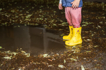 little boy outdoors playing in the rain.