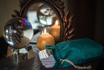 Magic crystal ball fortune teller ,love telling,  esoteric concept, mystical scene with candles, tarot cards on a table