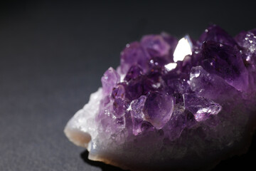 Beautiful amethyst on grey table, closeup. Healing crystal