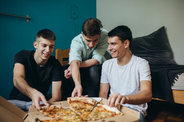 teenagers having fun eating pizza at home