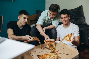 teenagers having fun eating pizza at home