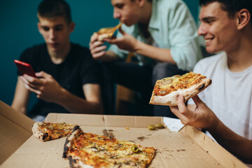 teenagers having fun eating pizza at home
