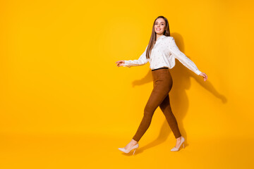 Fototapeta na wymiar Full length body size view of her she nice-looking attractive lovely pretty fashionable glad cheerful cheery straight-haired girl walking isolated bright vivid shine vibrant yellow color background