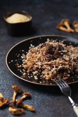 Cooked buckwheat with dried mushrooms on a plate sprinkled with Parmesan. Vegetarian food. Russian, Ukranian cuisine.