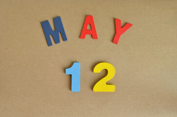 May 12, Toy alphabet with a brown background.