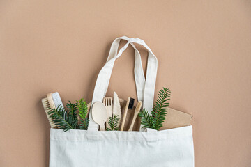 Cotton eco bag.  Zero waste concept.   Zero Waste Cotton Bag.  Eco friendly and reuse concept. Wooden toothbrushes, paper dishes, green leaves. Top view, flat lay,  copy space.