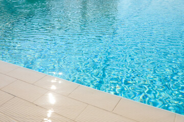 Fototapeta na wymiar Outdoor swimming pool with clear water on sunny day. Summer vacation