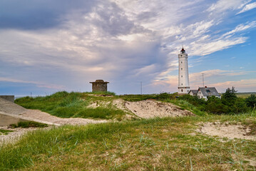Fototapeta na wymiar The historic lighthouse Blåvandshukfyr at the westernmost point of denmark with scenic dramatic sky because a thunderstorm is catching up