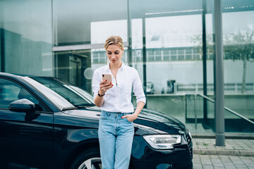 Female driver using smartphone near vehicle © BullRun