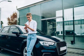 Confident driver using smartphone near car