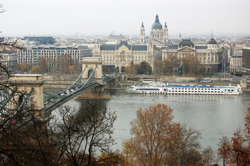 View of the Chain Bridge, Danube River and white pleasure boat in Budapest in autumn, Hungary.