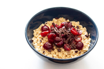 Oatmeal with cherry and chocolate in a blue bowl isolated on white background