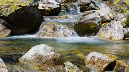 Naklejka na ściany i meble closeup rushing mountain river with small waterfall