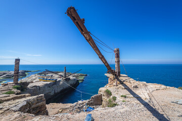 Rusty old crane on the Mediterranean coast in Beirut, capital city of Lebanon, next to famous Raouche Rocks