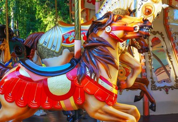 Attraction children's colorful carousel in retro style horse closeup