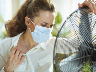 female suffer from heat at modern home in sunny hot summer day