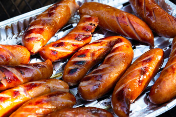 Grilled sausage on aluminium tray