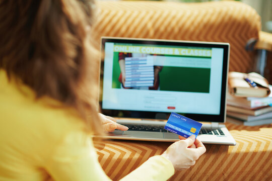 woman subscribing to online school in house in sunny day - Powered by Adobe