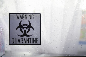 Obraz premium Quarantine. Quarantine warning sign on a glass door in a hospital isolator. Isolation of patients with the virus in special laboratories. Virus.