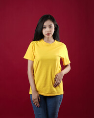 Front view white t-shirt Closeup on female body, woman girl in empty yellow t-shirt isolated on red background. Design woman t-shirt template and mockup for print.