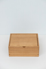 Large wooden box with a separator on a light mint background empty. Product Display Concept. Copy space. Oak box on the table, for installation. Vertical photo