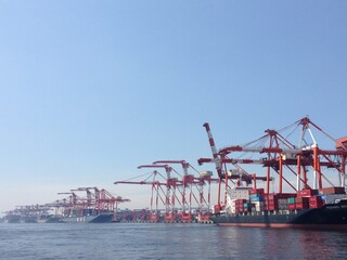 海辺工場地帯のガントリークレーンとコンテナ