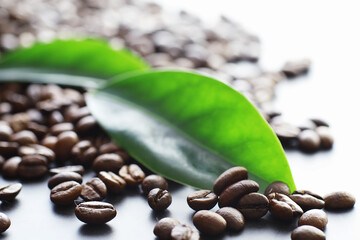 Obraz premium Bag of coffee. Coffee beans roasted on the table. Coffee beans with green leaves for cooking.