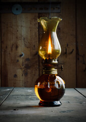 Old burning oil lamp on table