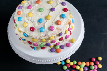 fun freshly baked layer cake with buttercream frosting and candies 